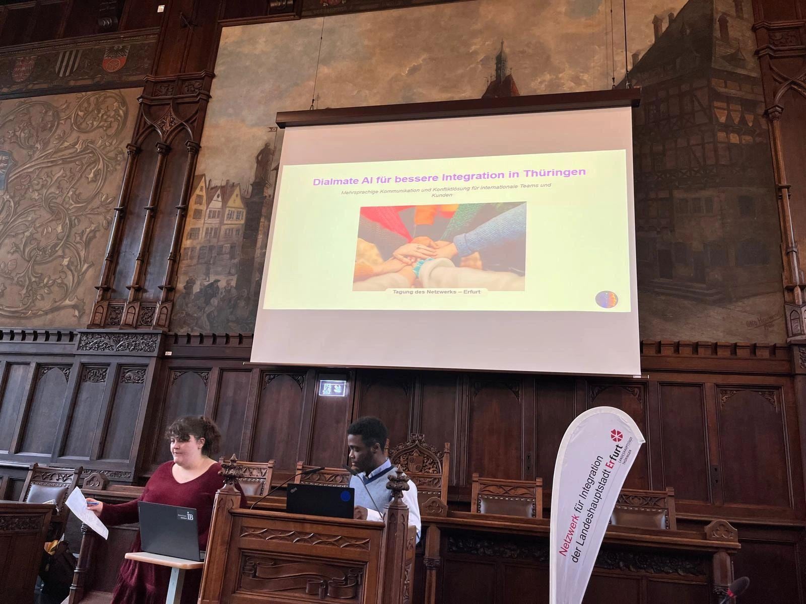 Aurel Nzeyap pitching Dialmate AI on stage in the ornate town-hall of Erfurt